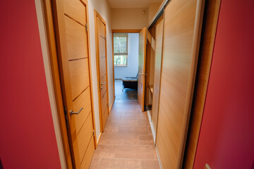 Narrow corridor with a closet and doors