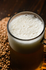 Beer mug with fresh foamy beer on a dark background.