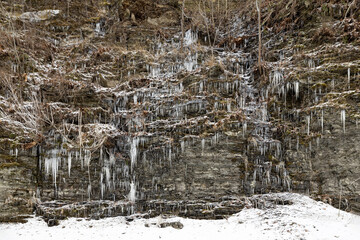 Water seeping out of a rock wall forms natural icicles along the gorge trail at Buttermilk Falls State Park, Ithaca, New York, USA