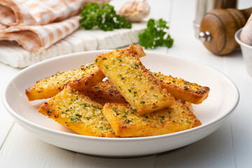 Crispy Garlic Bread on white plate.Air fryer bread with butter garlic and parsley.Snack food