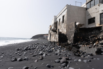 Une maison abandonnée sur les bords d'une plage de sable noir