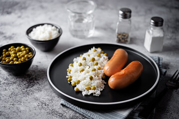 Fried sausages with rice in a plate.
