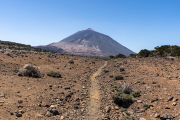 un chemin de terre qui va droit vers un volcan