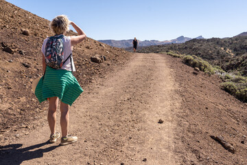 une femme sur un chemin de randonnée qui attend une autre randonneuse