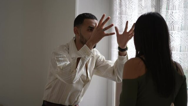 Young Couple Arguing and Fighting. Emotional abuse Scene, Stressed Woman and frustrated Man Screaming at Each other by window at home. Dramatic Scene