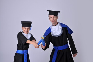 formatura pai e filho iguais com roupas de formandos acadêmicos graduados  