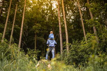 Father son hiking in the forest spending time together going on a nature adventure 