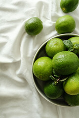 foto superior de limão verde sobre fundo neutro claro com tecido com espaço para texto sem pessoa