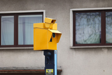 Żółty fotoradar robi zdjęcia wykroczeń drogowych kierowcom samochodów.  - obrazy, fototapety, plakaty