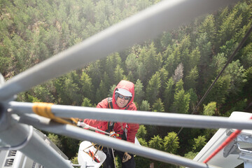 Telecommunication engineer installing 5G LTE antenna on the top of communication tower. Working at...
