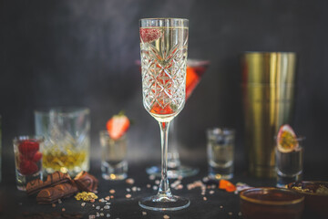 Side view of Chilled Prosecco, raspberry garnish, assorted cocktails, dark background, elegant drinks, stylish presentation
