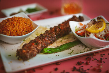 Close-up of delicious kebab on white plate, vibrant pink background, mouthwatering, colorful and tempting