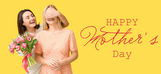 Beautiful woman and her daughter with bouquet of flowers on yellow background. Mother's Day...