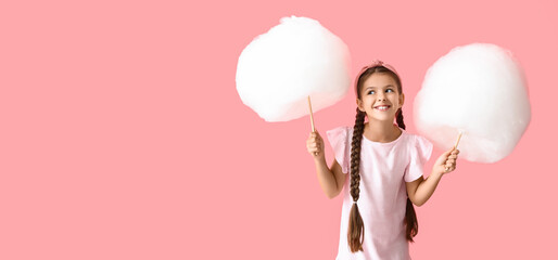 Cute little girl with cotton candy on pink background with space for text