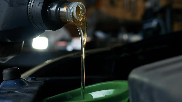 pouring new engine oil into a car engine, car maintenance.