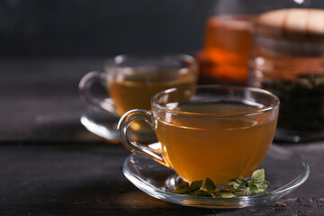 Cup of hot green tea on table