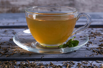Cup of hot green tea on table, closeup