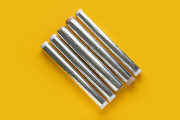 Aluminium foil rolls on yellow background