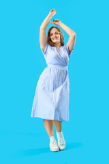 Naklejka premium Beautiful woman with red hair on blue background