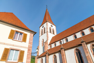 Fototapeta na wymiar The exterior and tower of the Eglise Saint-Martin, the historic church in the Alsatian town of Ammerschwihr, France, one of the smaller towns along the Wine Route of the Alsace region.