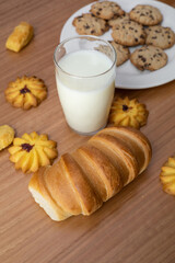 wallpaper of a pastry shop table, with delicious cookies, glass of milk and fresh bread, food and sweets in studio, lifestyle