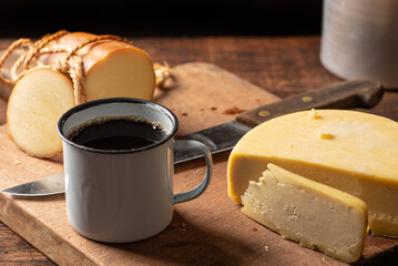 Cheese and coffee, typical scene from Brazil with different cheeses and coffee on a rustic wooden table, selective focus.