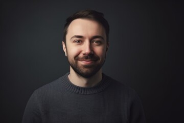 Fototapeta premium Portrait of a handsome young man in a sweater on a dark background