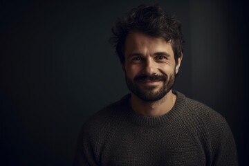 Fototapeta premium Portrait of a handsome man in a gray sweater on a dark background