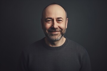 Fototapeta premium Portrait of a smiling middle-aged man on a dark background