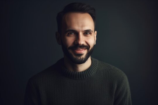 Portrait of a handsome bearded man in a sweater on a dark background