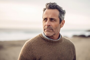 Lifestyle portrait photography of a pleased man in his 40s wearing a cozy sweater against a beach background. Generative AI