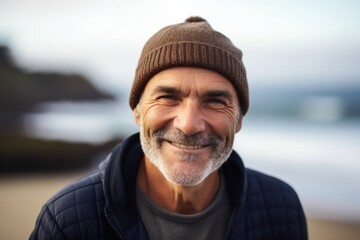 Fototapeta na wymiar Headshot portrait photography of a pleased man in his 50s wearing a warm beanie or knit hat against a beach background. Generative AI