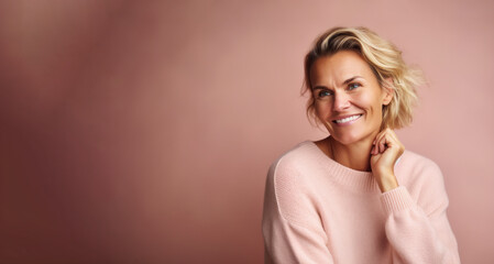 Fototapeta premium Portrait of a beautiful woman with blond hair in a pink sweater