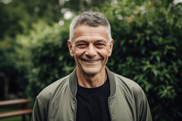 Portrait of a smiling senior man in a park. Mature man in a park.