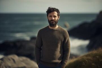 Fototapeta na wymiar Portrait of a handsome bearded man wearing a sweater on the beach