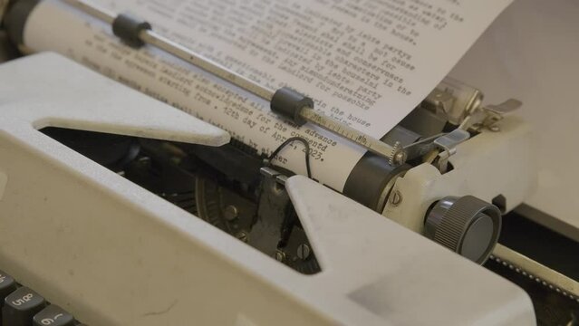 African man typing on a vintage manual mechanical typewriter.