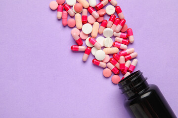 Bottle with pills on lilac background