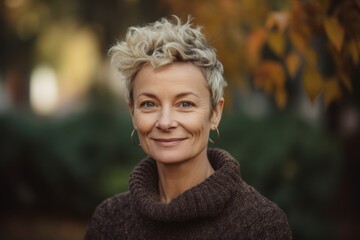 Portrait of a beautiful smiling middle-aged woman in autumn park