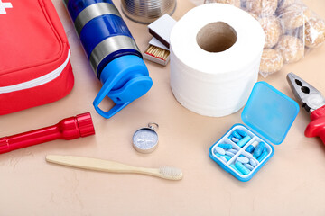 Necessities for emergency bag on beige background, closeup