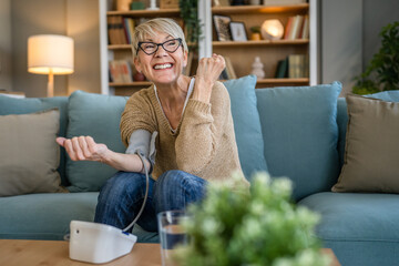 Senior caucasian woman check blood pressure measure device on hand