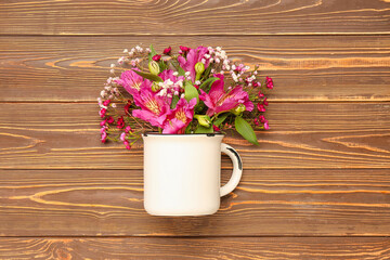 Cup with beautiful flowers on wooden background