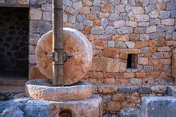 Fototapeta na wymiar An ancient hand mill made of stones and wood. Stone milling is a traditional part of the bread production process. Anatolia culture.