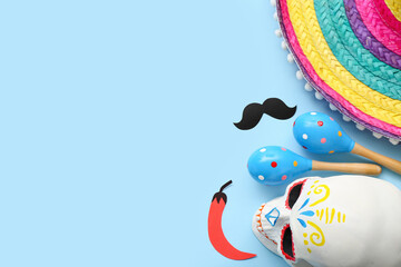 Mexican maracas, paper mustache, chili pepper, painted skull and sombrero hat on blue background