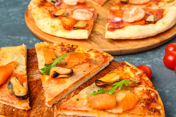 Plate with slices of tasty seafood pizza on blue background, closeup