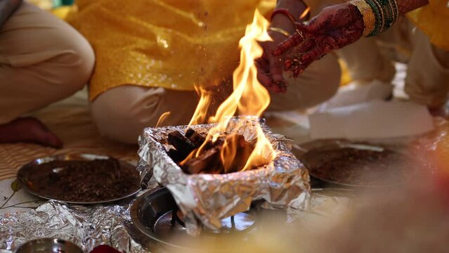 Close-up view of unrecognized people in traditional clothes throwing spices into open fire. Religious Hindu ritual practicing. High quality 4k footage