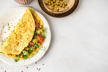 Tasty omelet with vegetables on light background