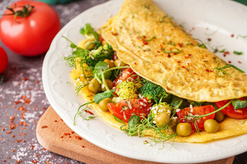 Tasty omelet with vegetables on grey grunge background