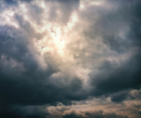 sunlight peeking through a dramatic cloudy sky