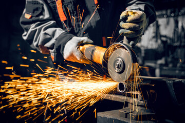 Angle grinder at work, sparks and dust from the cut-off stone. - obrazy, fototapety, plakaty