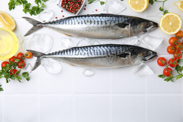 Raw mackerel, peppercorns and tomatoes on white tiled table, flat lay. Space for text